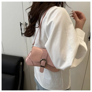Pink glossy faux leather underarm bag with large silver metal buckle on white shirt