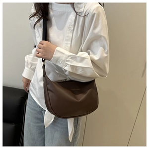 Détail d'un sac hobo marron en demi-lune avec bandoulière large porté croisé