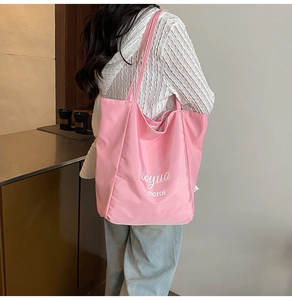 Model view of pink large capacity canvas tote bag with artistic letter printing