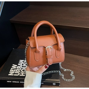 Vue détaillée du mini sac en cuir caramel avec bandoulière chaîne argentée et poignées