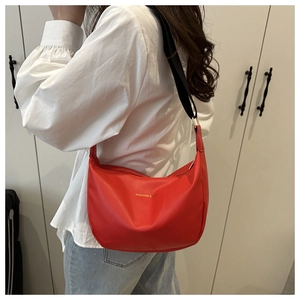 Vue détaillée du sac hobo rouge avec texte doré et large bandoulière noire