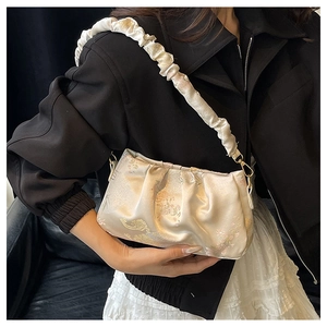 Detail of light gold satin shoulder bag with vintage Chinese style embroidery patterns