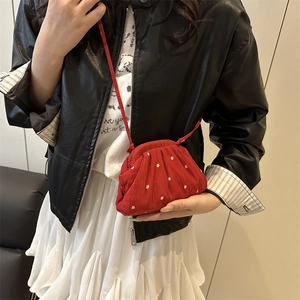 Borsa rossa a fiori indossata con giacca di pelle e gonna a pieghe bianca elegante