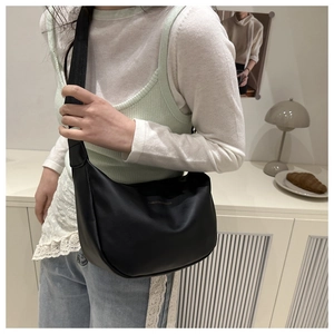 Détail du cabas en cuir PU noir avec texte doré et large bandoulière élégante