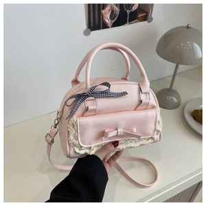 Detail of light pink shell bag with lace trim, bows and checkered ribbon accents