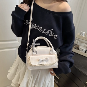 Chic beige shell-shaped shoulder bag with lace trim and bow on indoor model