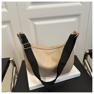 Détail du sac croissant beige avec bandoulière noire et texte doré FASHION & BAGS