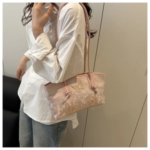 Detail of pink lace shoulder bag featuring 3D butterfly appliques and floral texture