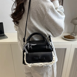 Chic black shell bag with white lace trim and bow accent for fashion forward women