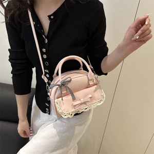 Pink shell handbag with lace trim and bow, shown on model as a stylish crossbody bag