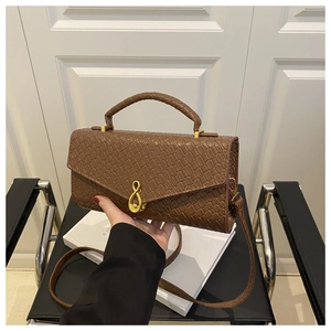 Detail of brown animal texture handbag with golden 8-shaped metal buckle and flip cover