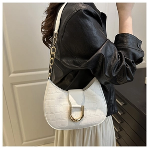 Detail view of white crocodile pattern crescent bag with golden U-shaped buckle and chain strap