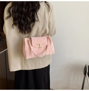 Dettaglio della pelle rosa stropicciata e della fibbia a T dorata sulla borsa chic