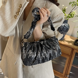 Chic black sequin baguette bag with a pleated scrunchie handle and gold hardware