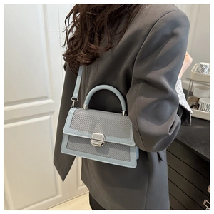 Detail of light blue crossbody bag with woven texture and silver square buckle lock