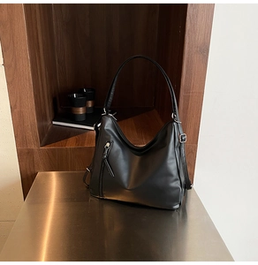 Detail view of premium black PU leather texture and adjustable metal buckle on shoulder bag