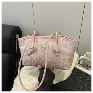 Detail of pink lace tote bag featuring 3D butterfly embroidery and elegant leather straps