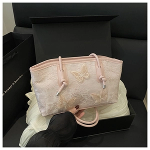 Close-up of light pink lace tote bag featuring 3D butterfly embroidery in a gift box