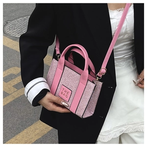 Close-up of pink crossbody tote bag with THE BAG text and sparkly fabric texture