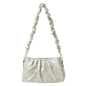 Silver jacquard shoulder bag with golden floral patterns and ruffled satin handle