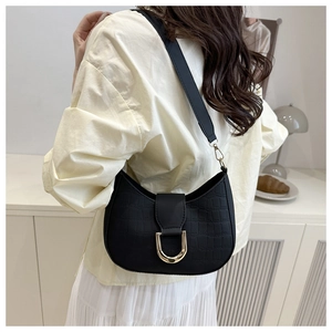 Detail of black crocodile texture crescent bag featuring a golden U-shaped buckle decoration