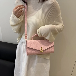 Pink woven texture shoulder bag with gold twist lock and elegant top handle strap