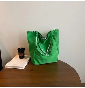 Detail of green nylon tote bag showing textured fabric and checkerboard lining