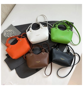 Top view of bucket bags in five colors with knot handle details on a suit jacket