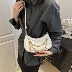 White croc-effect half-moon shoulder bag with double gold chains shown on a model