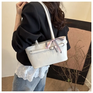 Détail du sac baguette en cuir PU blanc avec nœud en ruban rose et boucles argentées