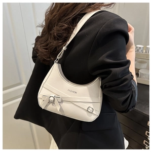 Close-up of white crescent moon bag featuring crossover straps and bow knot detail
