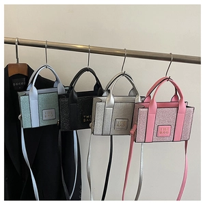 Detail showing four sequined mini tote bags in mint green, black, silver, and pink