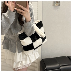 Detail of the soft plush tote bag featuring a black and white checkerboard pattern