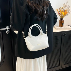 White lychee leather bucket bag with top handles and golden text on a minimalist background
