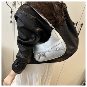 Detail der silbernen Crescent-Hobo-Tasche mit Metallriemen, getragen von einem Model