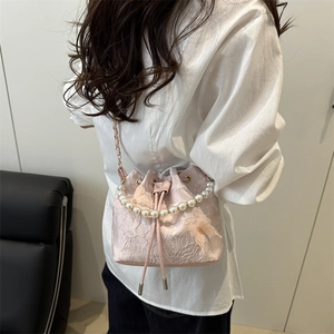 Pink lace drawstring bucket bag with pearl handle and golden chain on model