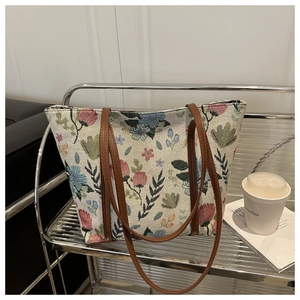 Détail du sac cabas vintage en jacquard fleuri avec des anses en cuir marron sur support
