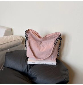 Détail du cabas en nylon rose avec bandoulière en corde tressée et logo brodé