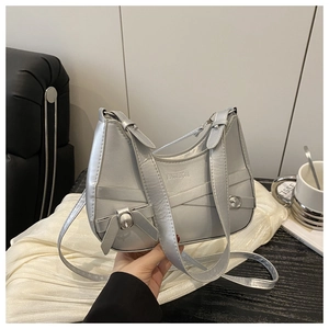 Detail der silbernen Halbmond-Hobo-Tasche mit Metallic-Finish und Zierriemen