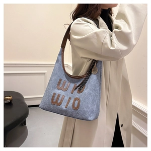 Sac bandoulière en denim bleu avec applique en cuir et breloque raquette de tennis dorée