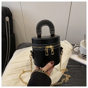 Détail du sac seau cylindrique noir avec surpiqûres blanches et garnitures dorées