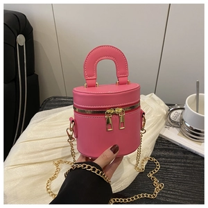 Détail d'un sac seau rose cylindrique avec doubles zips dorés et bandoulière