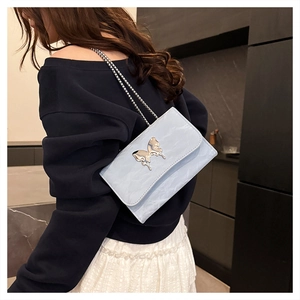 Detail of light blue crossbody bag with marble texture and silver butterfly buckle