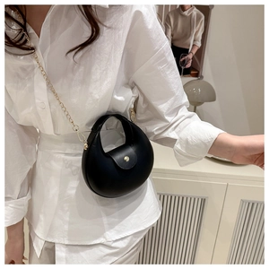 Side view of a black crescent moon bag featuring a chic gold chain strap and matte finish