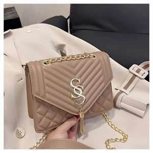 Close-up of brown quilted faux leather handbag with gold S logo and chain strap