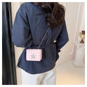 Close-up of pink quilted mini crossbody bag with rhinestone star and silver chain