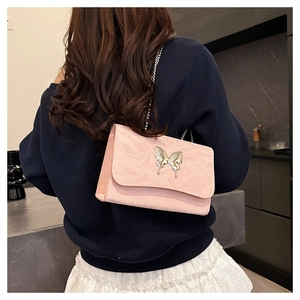 Back view of pink pleated shoulder bag with silver butterfly clasp and chain strap