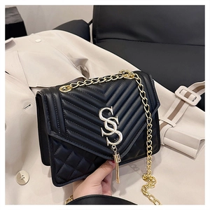 Detail of black quilted crossbody bag with golden V-line stitching and S-logo fringe