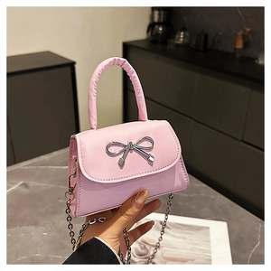 Detail of a pink PU leather mini handbag featuring a silver bow buckle and chain strap