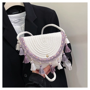 Gros plan d'un sac à bandoulière en coton tissé main avec franges lilas et spirales
